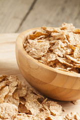 Whole grain wheat cereal for breakfast in a wooden bowl, selecti