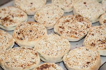 cooking Indian snacks alupatras with sesame seeds