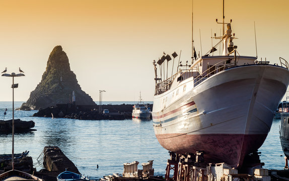 Acitrezza harbor with old boat