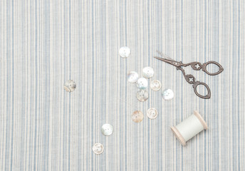 Pearl Buttons And Scissors On Natural Linen Striped Textile