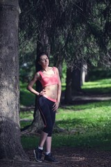 Portrait of fashion fitness model posing in park