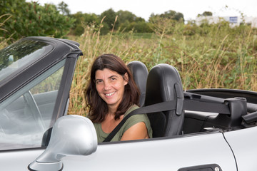 Woman in convertible car smiling