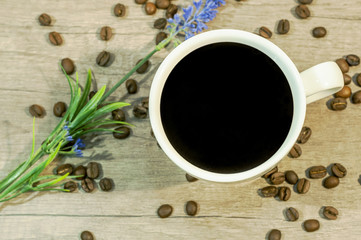Cup of hot drink with coffee beam and lavender flower on wooden