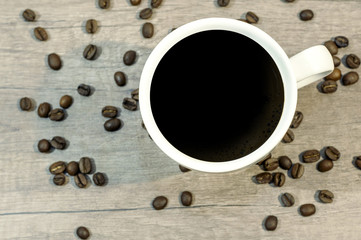 Cup of hot drink with coffee beam on wooden table