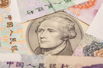 Fototapeta premium Ten dollar bill surrounded by Chinese Yuan