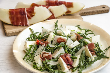 Italian salad with melon ham and arugula  
