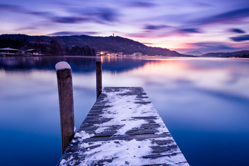 Sonnenuntergang im Winter mit See, Steg und Schnee