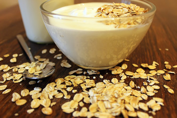 Bowl of greek yogurt with oatmeal and seeds on wooden table