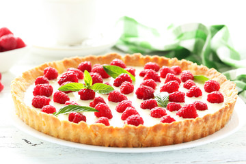 Sweet tart cake with raspberries on white wooden background