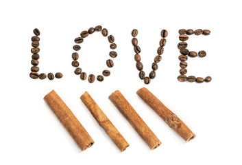 The word love writen with coffee beans and cinnamon stick on whi