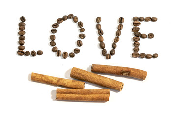 The word love writen with cinnamon stick and coffee beans on whi