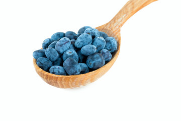 Honeysuckle berries in a wooden spoon