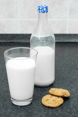Bottle of milk, a glass of milk and cookies on the table