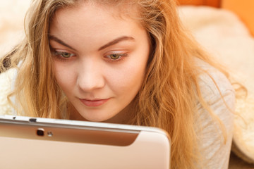 Young woman girl with tablet browsing internet.