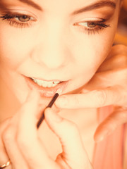 Attractive woman applying lipstick. Make up.