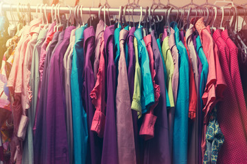 Clothes hang on a shelf in a designer clothes store in retro col