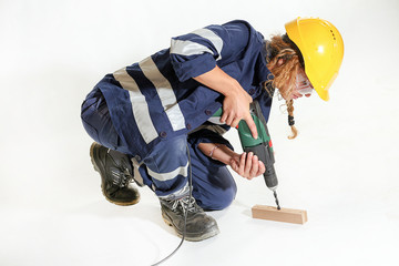 Young girl with helmet and work the drill