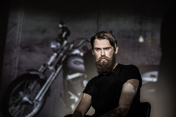 Fototapeta na wymiar Brutal angry biker on a dark background.