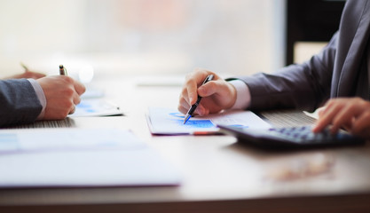 Two business people working sitting at the table. Close up of hands