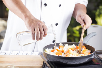Chef pouring soup to the pan for cooking Japanese pork curry