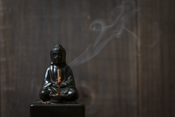 Burning Incense on Buddha Statue with Curling Smoke