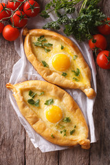 Georgian khachapuri and fresh vegetables closeup vertical top view
