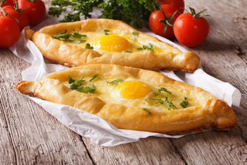 Rustic khachapuri and fresh vegetables close-up. horizontal
