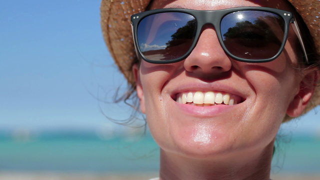 Portrait of a beautiful woman face in summer with a warmth light on the beach, close up