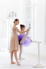 The little ballerina posing at ballet barre with personal