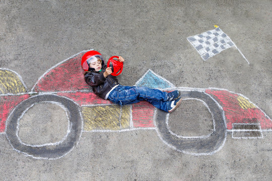 Little Boy Having Fun With Race Car Drawing With Chalks