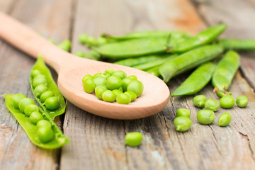 Freshly picked green peas on a wooden table.