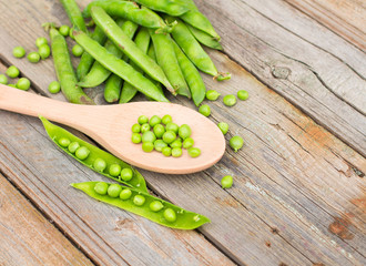 Freshly picked green peas on a wooden table.