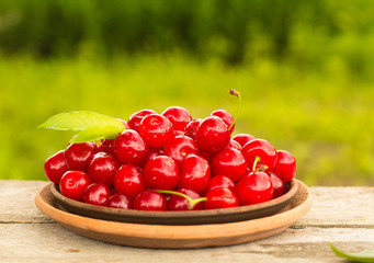 Cherries on wooden table with water drops macro background