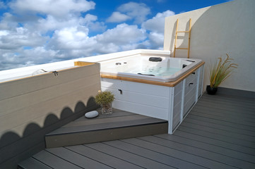 White Jacuzzi on wood plastic composite (WPC) integrated grey terrace.