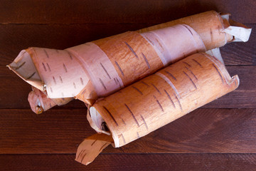 rolled up in roll birch's bark on a wooden background
