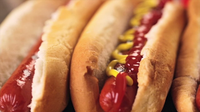 Grilled hot dogs on a white hot dog buns with mustard and ketchup