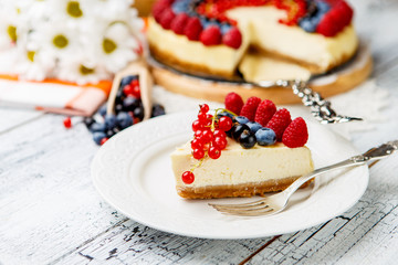 Raspberry and blueberry cheesecake on wooden table