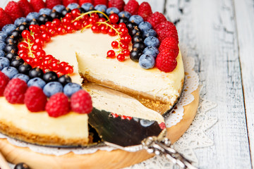 Raspberry and blueberry cheesecake on wooden table