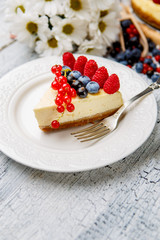 Raspberry and blueberry cheesecake on wooden table