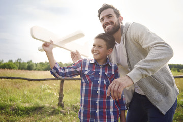 Father and son testing a paper plane