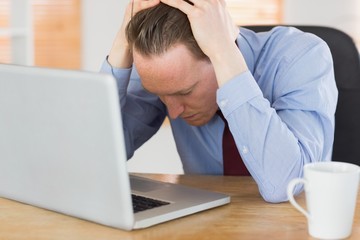 Stressed businessman with head in hands