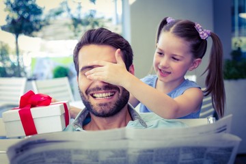 Daughter offering her present to her dad