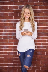 Stylish blonde woman smiling and using smartphone