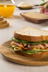 Sandwich on a white plate with turkey breast, tomato and lettuce