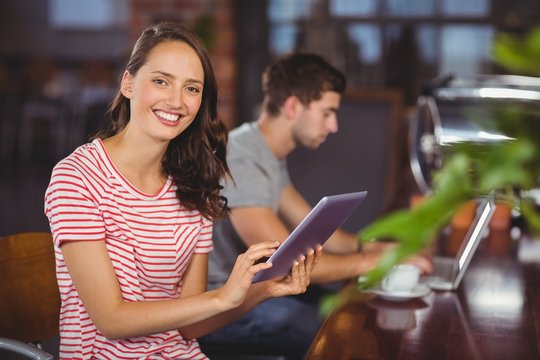 Smiling young woman using tablet computer