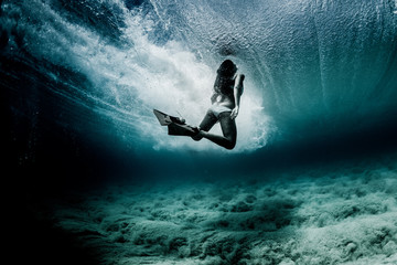 Woman swimming underwater wearing diving flippers, Hawaii, USA