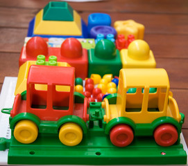 train and other plastic toys on a wooden base