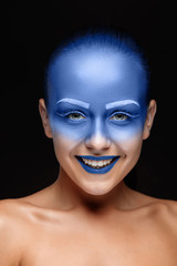 Portrait of a woman who is posing covered with blue paint