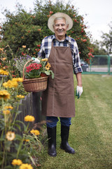 Happy retiree holding basket full of flowers