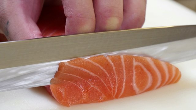 Sushi Chef Slicing a Salmon Steak Nigiri Style.
A sushiman slicing a salmon steak with his Japanese knife.
Preparing sushi nigiri fish.
Japanese cuisine recipes.